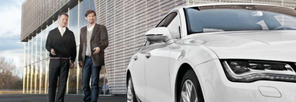 A salesman leading a customer to a car featured in a blog post about CPO Audi cars